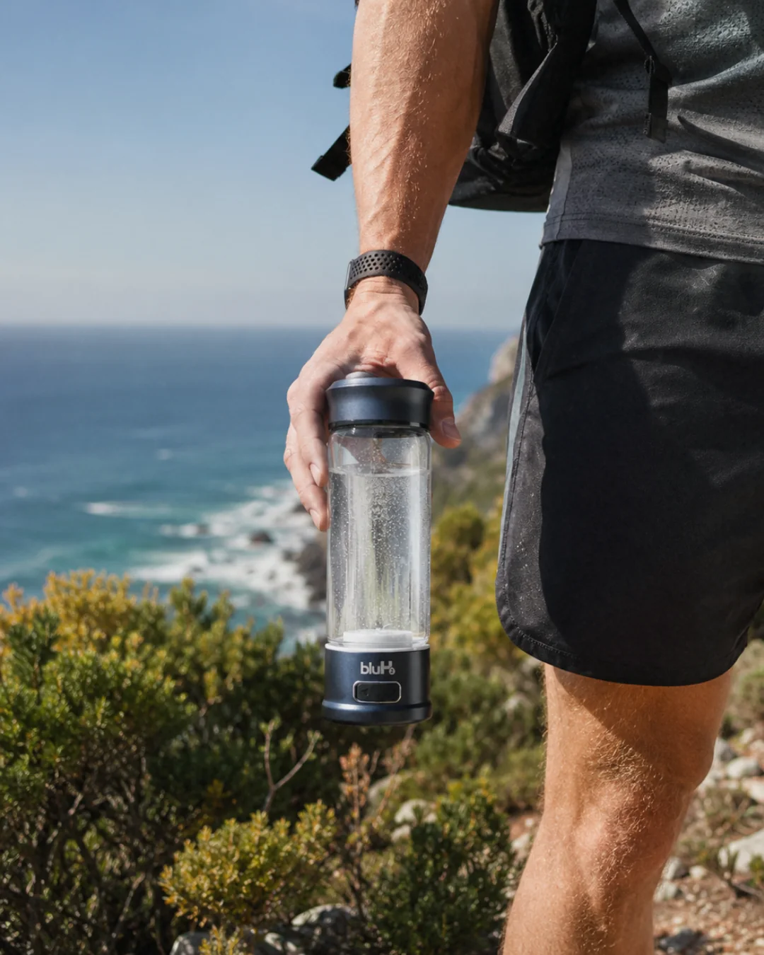 Man carrying a BluH2 Flow bottle beside the ocean